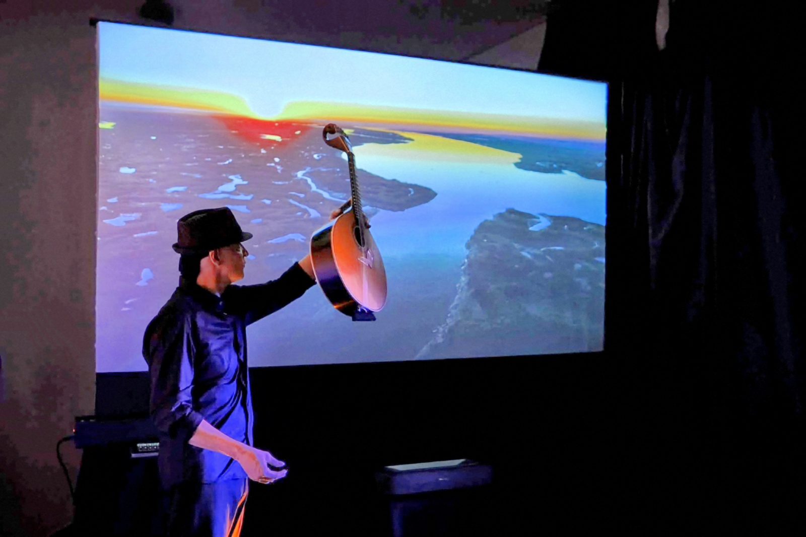 Guitar raised in front of the projected Ria Formosa
