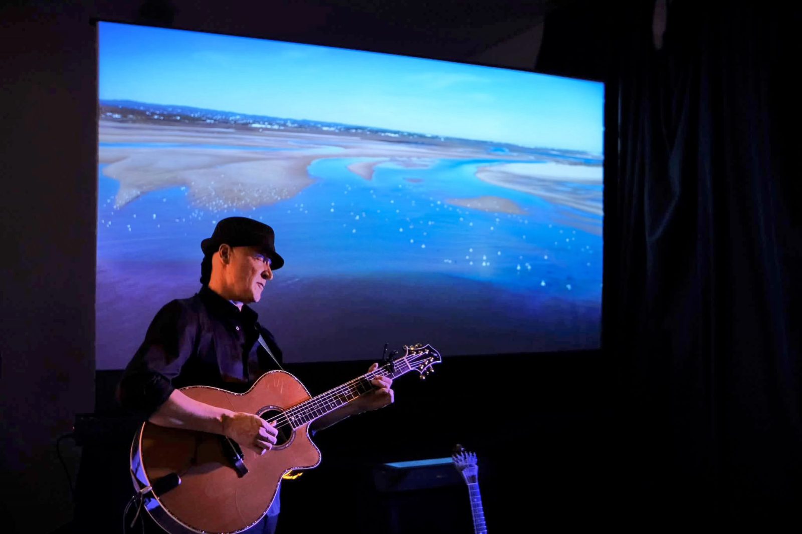 João Cuña on stage with an acoustic guitar